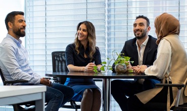 Four colleagues sitting around a table at the office